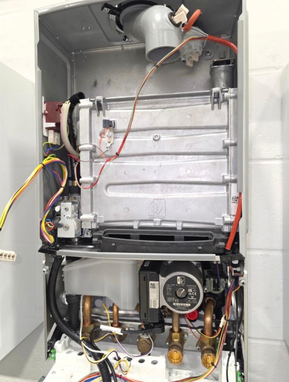 Full internal view of a stripped combi boiler with heat exchanger, gas valve and pump exposed